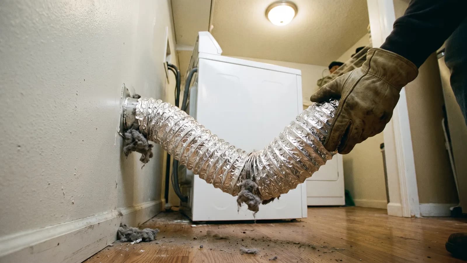Crushed foil dryer vent duct clogged with lint behind a dryer